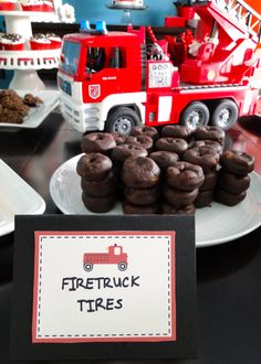 a firetruck themed birthday party with chocolate cookies and cupcakes on a plate