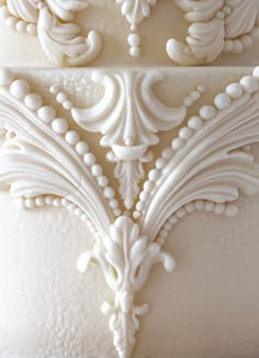 close up view of the intricately detailed design on this wedding cake, which features white frosting