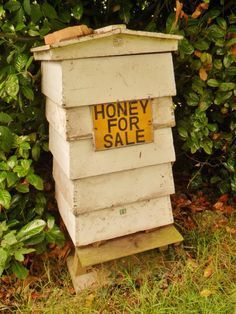 a beehive with a honey for sale sign on it