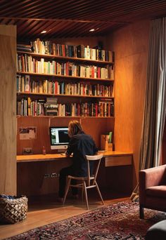 a person sitting at a desk in front of a book shelf