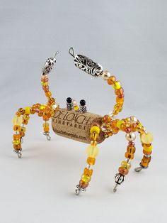 a crab made out of wine corks with beads on it's legs and feet