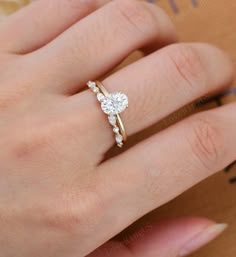 a woman's hand with a diamond ring on her finger and an engagement band