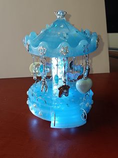 a blue glass carousel on top of a wooden table