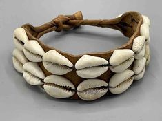 These traditional bracelets were worn by both men and women for protective purposes, as well as personal adornment. The leather, made from goatskin, would have contained items of medicinal or spiritual value which defend the wearer from whatever he or she may consider to be threatening to them. Cowrie shells, prior to European occupation, were currency and so still reflect their former significance. The clasp for each is the traditional ball and loop style. These cowrie shells are the real thing Bohemian Jewelry With Leather Strap, Traditional Adjustable Leather Jewelry, Adjustable Traditional Leather Bracelet, Traditional Leather Jewelry For Festival, Traditional Leather Bracelet, Spiritual Brown Leather Bracelets, Brown Leather Spiritual Bracelets, Traditional Brown Leather Bracelet As Gift, Traditional Adjustable Leather Bracelet For Festivals