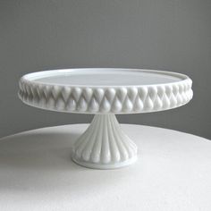 a white cake plate sitting on top of a table