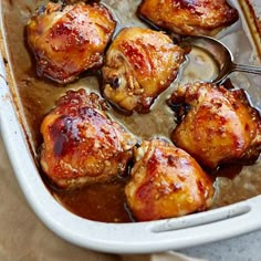 chicken thighs with sauce in a white casserole dish