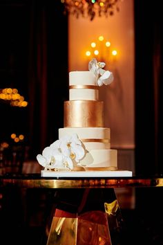 a white and gold wedding cake on a table