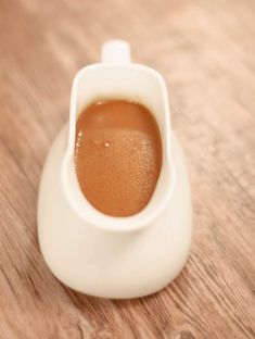 a cup filled with liquid sitting on top of a wooden table