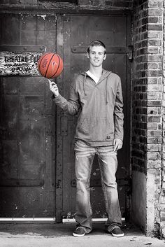 a man holding a basketball in front of a door