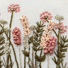 some pink and white flowers sitting on top of a piece of cloth next to each other