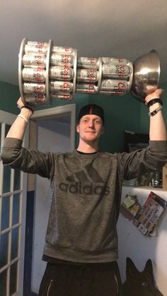 a man holding up two silver cups over his head