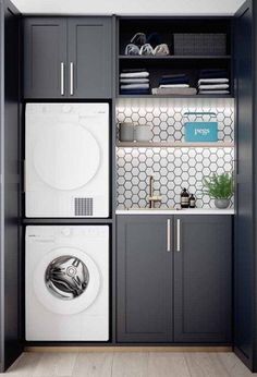 a washer and dryer in a laundry room with gray cabinetry, white tile backsplash, and wooden floors