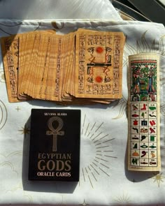 egyptian god's oracle cards and an ancient book on a tablecloth with gold designs