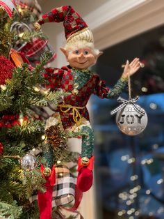 an elf ornament hanging from a christmas tree