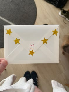 a person holding an envelope with gold stars on it