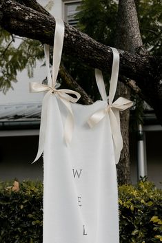 a white t - shirt hanging from a tree with the words we are married on it