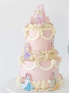 a three tiered cake with princess figures on it