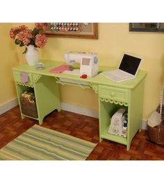 a laptop computer sitting on top of a green desk next to a white sewing machine