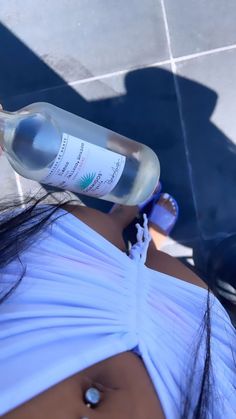 a woman in a white dress holding a bottle of water