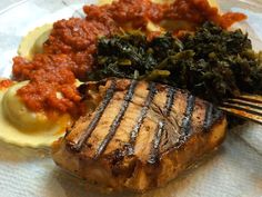 a steak, mashed potatoes and spinach on a plate with a fork in it