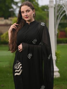 This is a three-piece black zebra saree set from the Ensembles collection. The black zebra saree is paired with a black sleeveless blouse. The blouse has front potli button opening, and a mandarin collar. There are beautiful zebra motifs of black and white bead work all over the saree. This saree set is crafted in pure organza fabric with contrast piping border. The outfit is completed with a heavily embellished, beadwork black and white zebra shape handbag. Elegant Black Pre-draped Saree With Mirror Work, Black Sets For Evening Eid Celebration, Black Evening Sets For Eid, Black Pre-draped Saree With Mirror Work For Designer Wear, Elegant Black Saree With Mirror Work, Black Georgette Blouse With Mirror Work, Designer Black Blouse With Mirror Work, Formal Black Saree With Mirror Work, Black Saree Blouse Piece For Eid