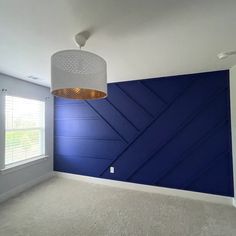 an empty room with blue walls and white carpet