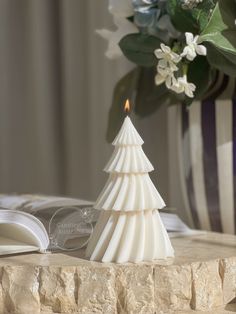 a small white christmas tree sitting on top of a table