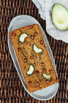 a loaf of bread with nuts and avocado on top