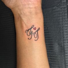 a woman's wrist with a small tattoo on it that says mom and heart