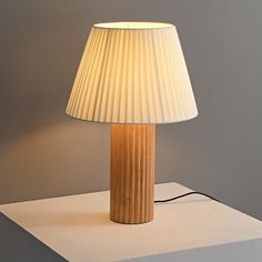 a table lamp sitting on top of a white surface next to a wall mounted light