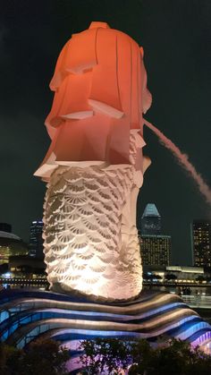 the statue is lit up at night with water shooting from it's back end