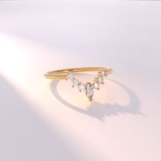 a gold ring with three diamonds on it, sitting on a white surface in the sunlight