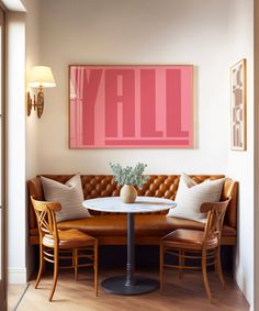 a living room with a couch, table and two chairs in front of a painting