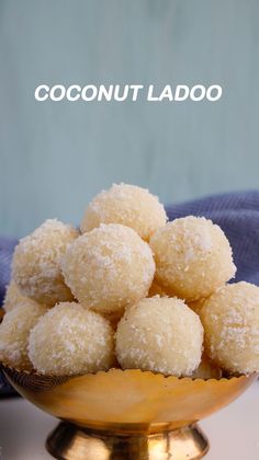 coconut ladoo in a gold bowl on a white surface with the words coconut ladoo above it