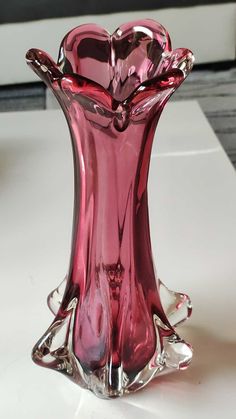 a pink vase sitting on top of a white table