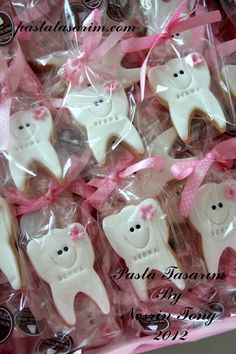 decorated cookies in the shape of teeth and pink bows are on display for people to see