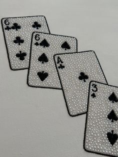 four playing cards with black and white designs on them are lined up next to each other