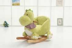 a green stuffed animal sitting on top of a wooden rocking horse