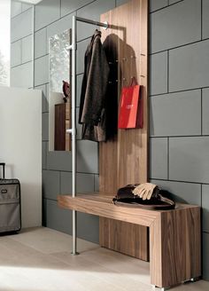 a wooden bench sitting next to a coat rack