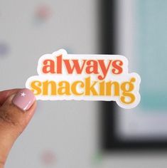 someone holding up a sticker that says always snacking