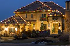 a large house with christmas lights on it's roof