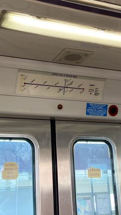 the inside of a subway car with two doors and signs on it's side