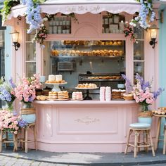 a pastry shop with pink and blue flowers on the outside, decorated in pastel colors