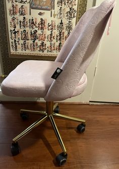 a pink office chair sitting on top of a wooden floor