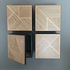 four pieces of carved wood sitting on top of each other in the shape of squares