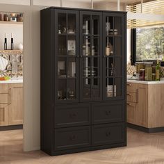 a tall black cabinet with glass doors in the middle of a wooden floored kitchen