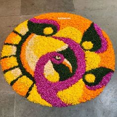 a colorful flower arrangement on the ground in front of a building with an eagle face painted on it