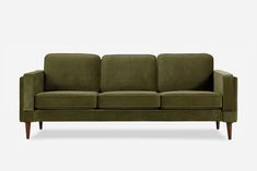 a green couch with wooden legs on a white background