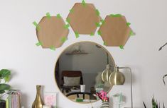 a mirror sitting on top of a dresser next to a plant and potted plants