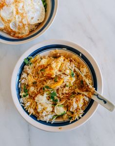 two bowls filled with rice and vegetables on top of a white countertop next to each other